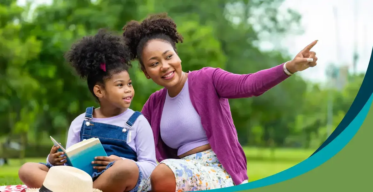Young girl reading with adult caregiver support Kids Read Now
