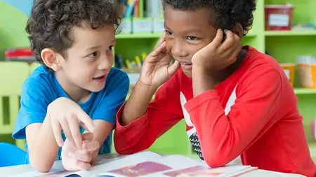 Two boys playing with a book