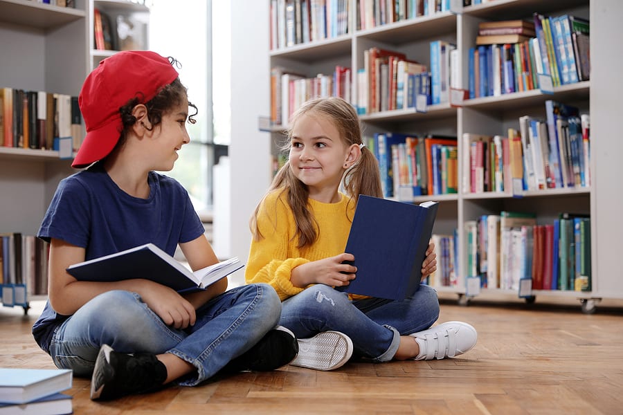 Cute Little Children Reading Books On Floor In Library; social-emotional learning