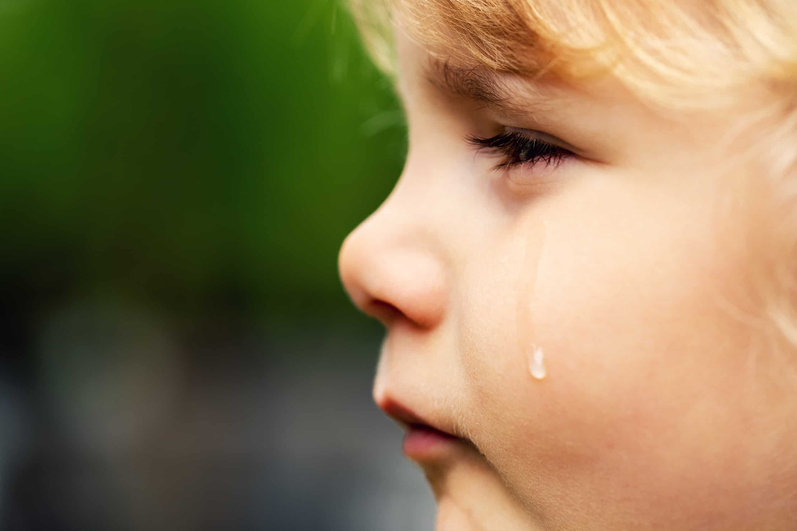 crying sad child - little girl face with tear on the cheek; normalizing emotions