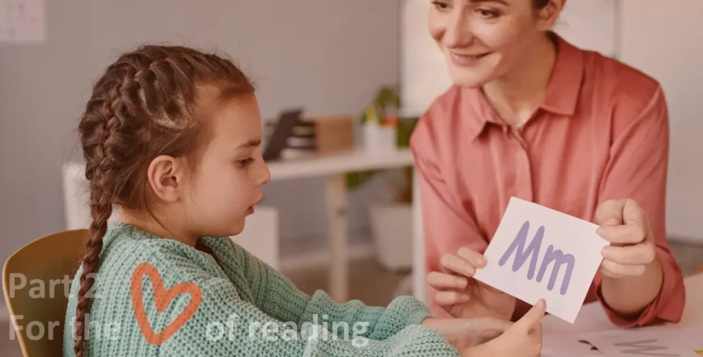 Young girl and adult learn letter sounds with flash cards.