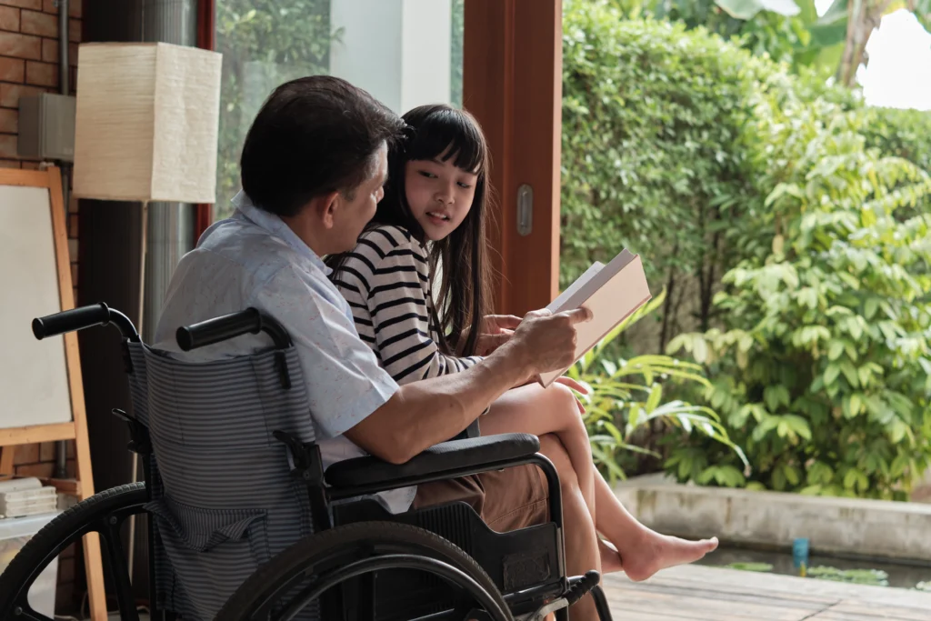 Grandpa in wheelchair reading aloud to granddaughter. Read-Alouds for Older Students - Kids Read Now 